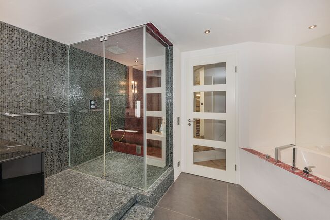 Badezimmer mit Dampfsauna und Badewanne